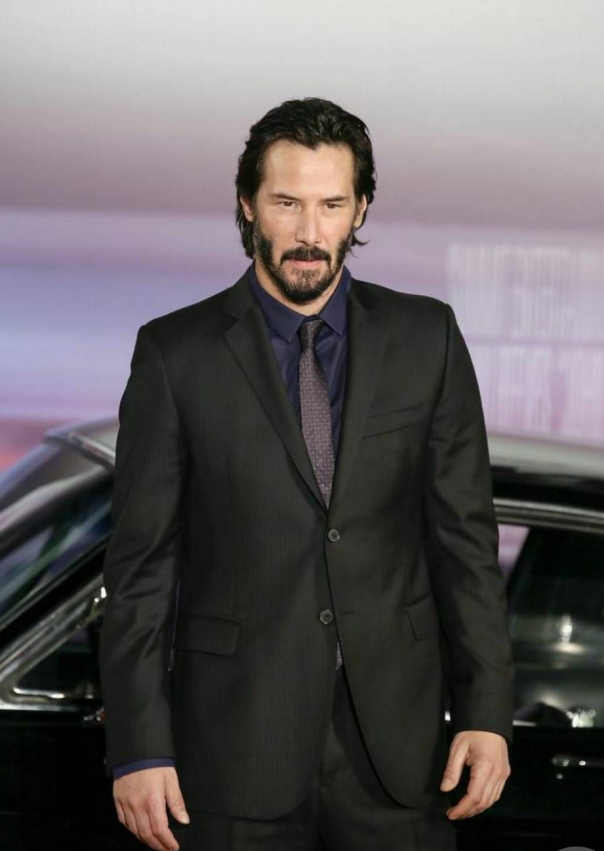 Keanu Reeves standing in front of car